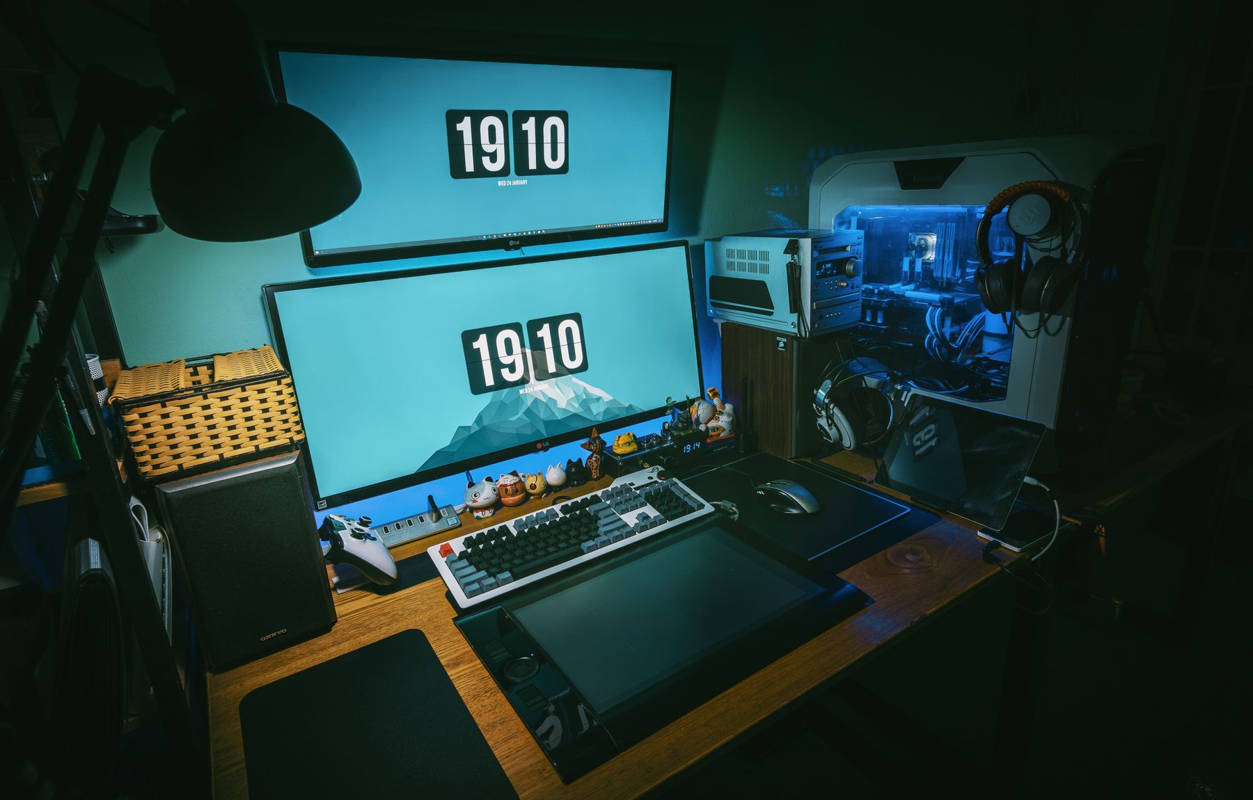 A dimly lit gaming desk with a dual-monitor setup